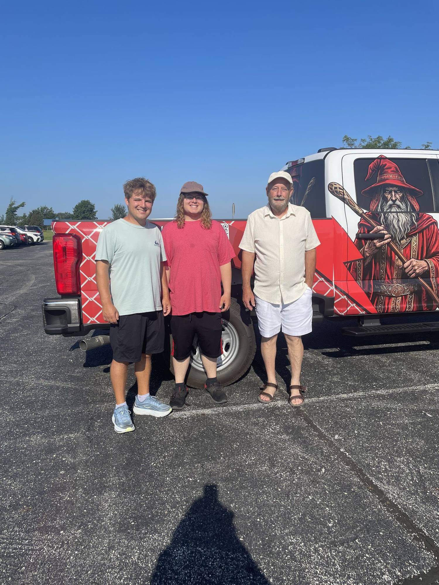 The Fence Wizards family crew in front of a wrapped work van
