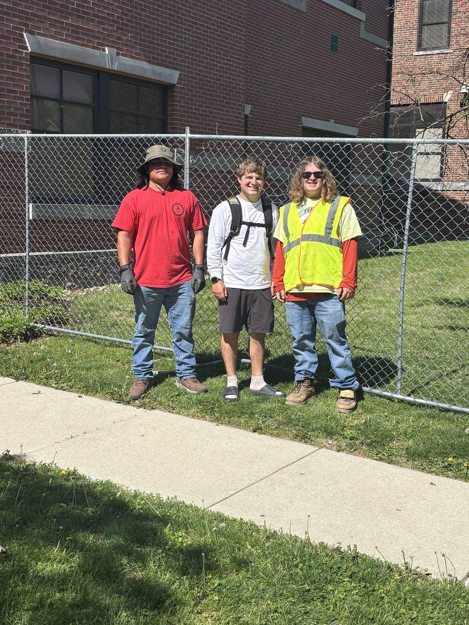 Three members of the Fence Wizards crew standing at a finished temporary fence line