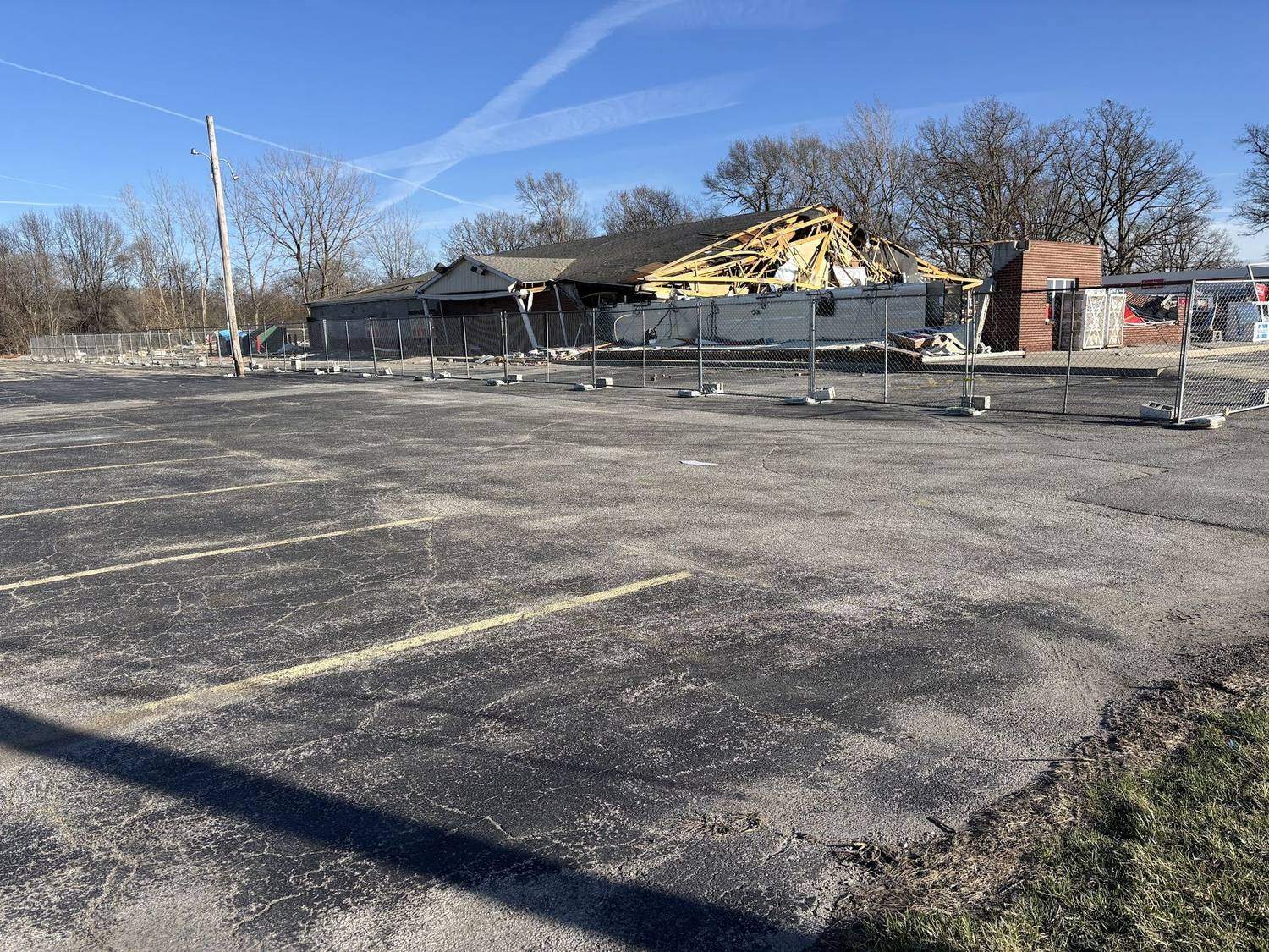 Temporary fencing holding a perimeter around a partly demolished building