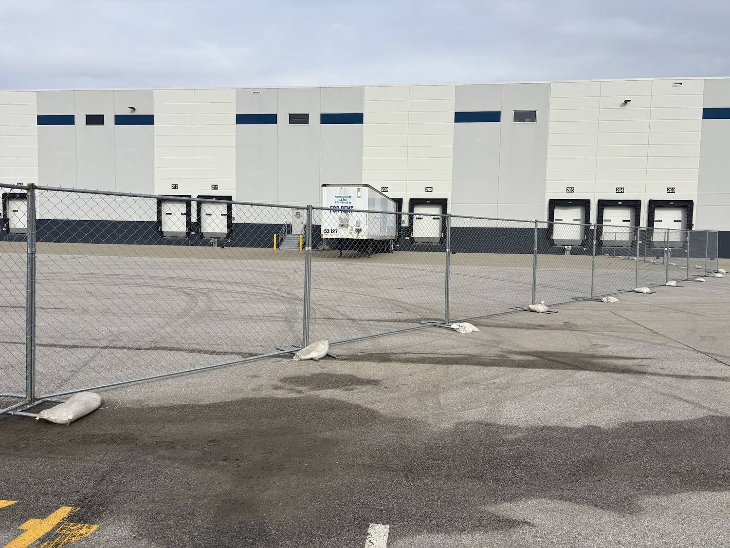 Temporary fence panels closing off the dock doors of a distribution warehouse near Indianapolis