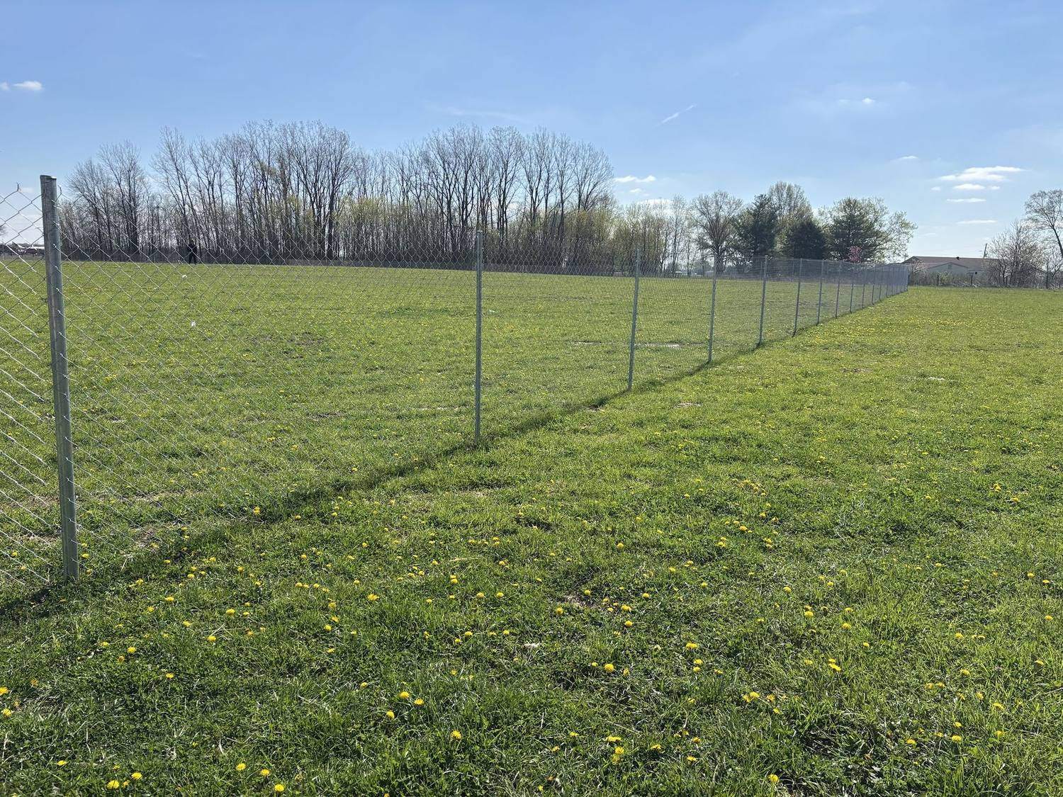 Temporary fence panels running the length of a grass field