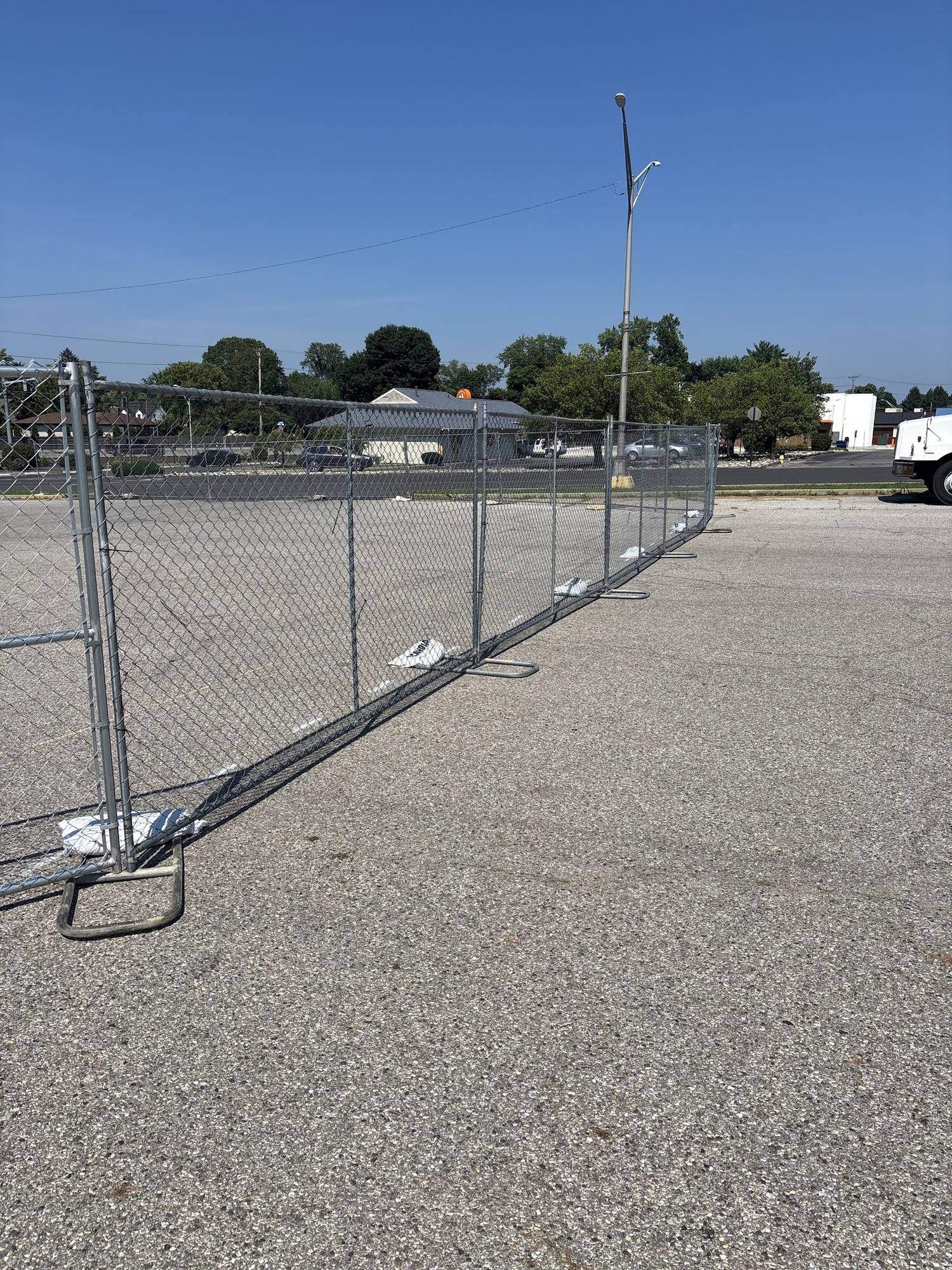 A temporary fence gate set across the entrance to a lot