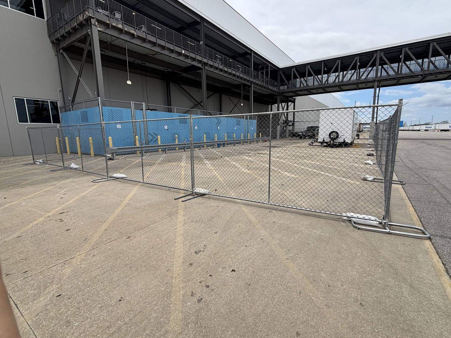 Temporary fence panels closing a loading area beside a commercial building