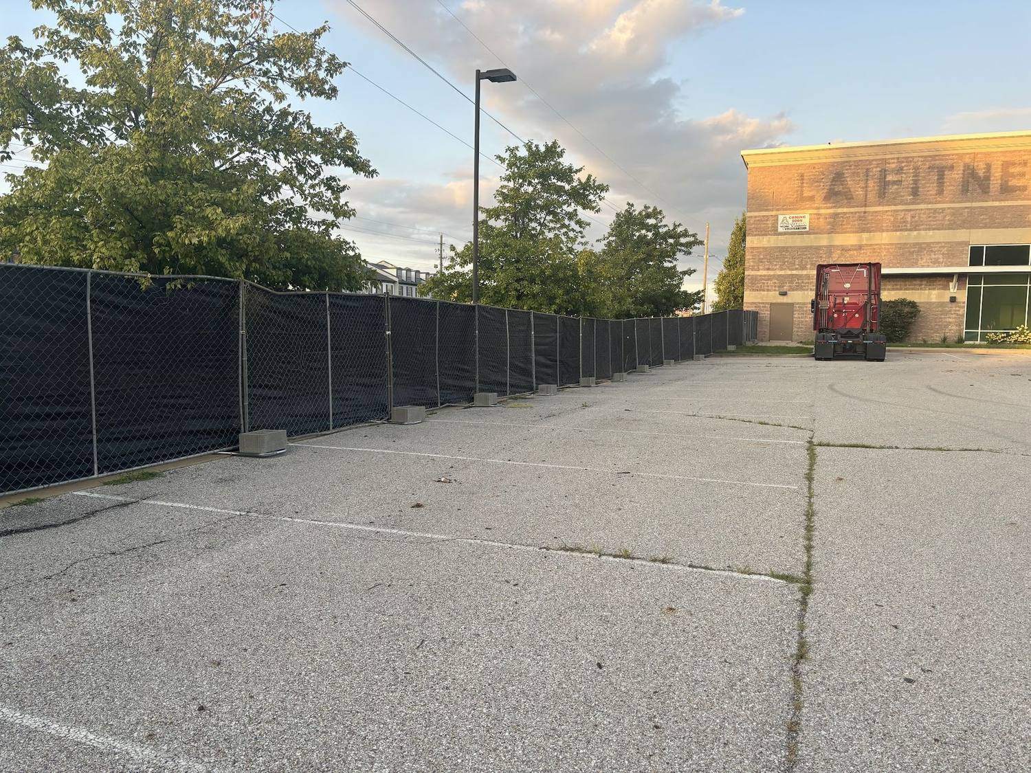 Windscreen on temporary fence along a sidewalk beside a venue