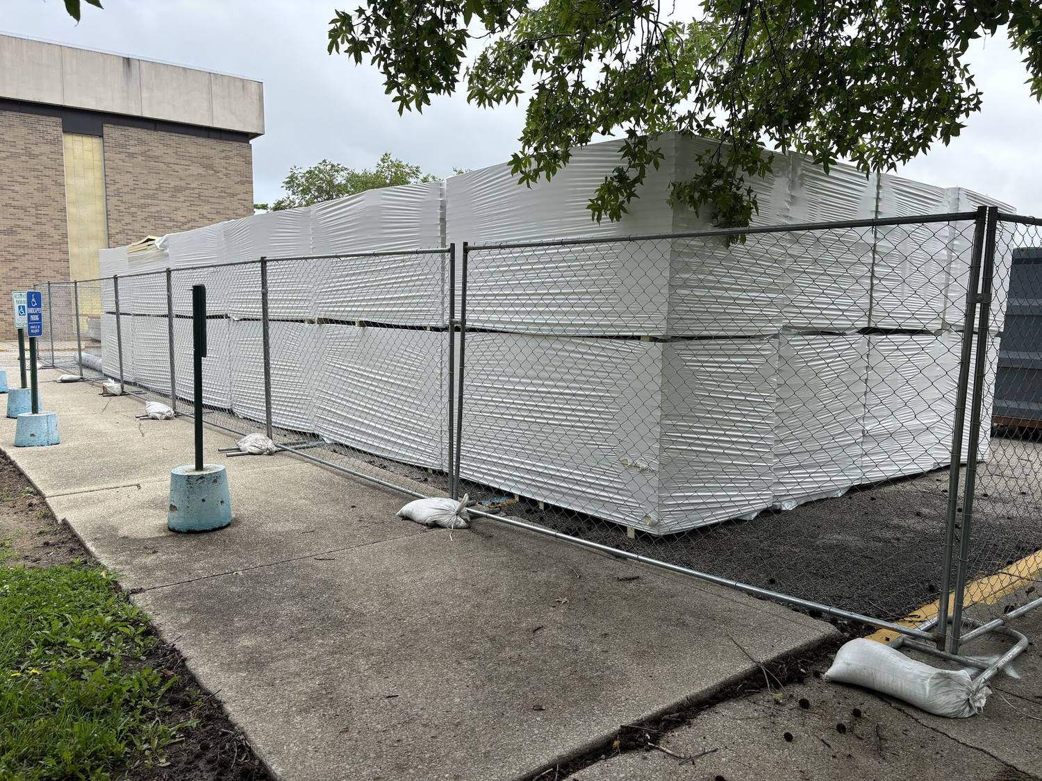 Temporary fence panels protecting stacked building materials on a job site