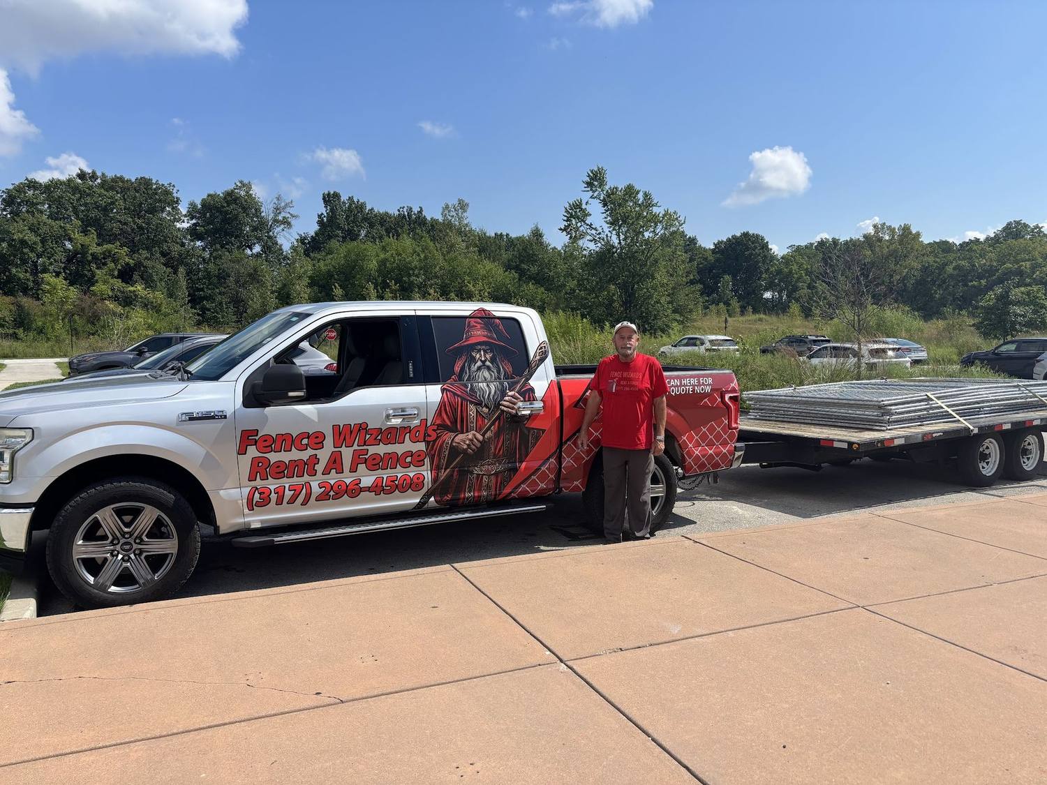A wrapped Fence Wizards truck with a trailer of fence panels ready to leave for a job