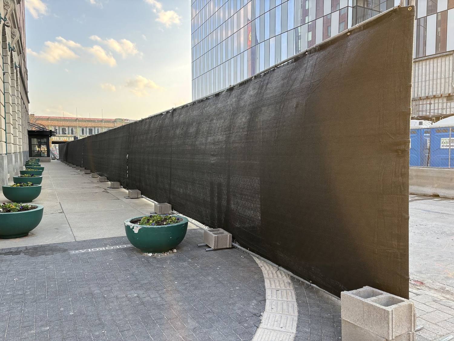 A long run of windscreen curving along a downtown Indianapolis sidewalk