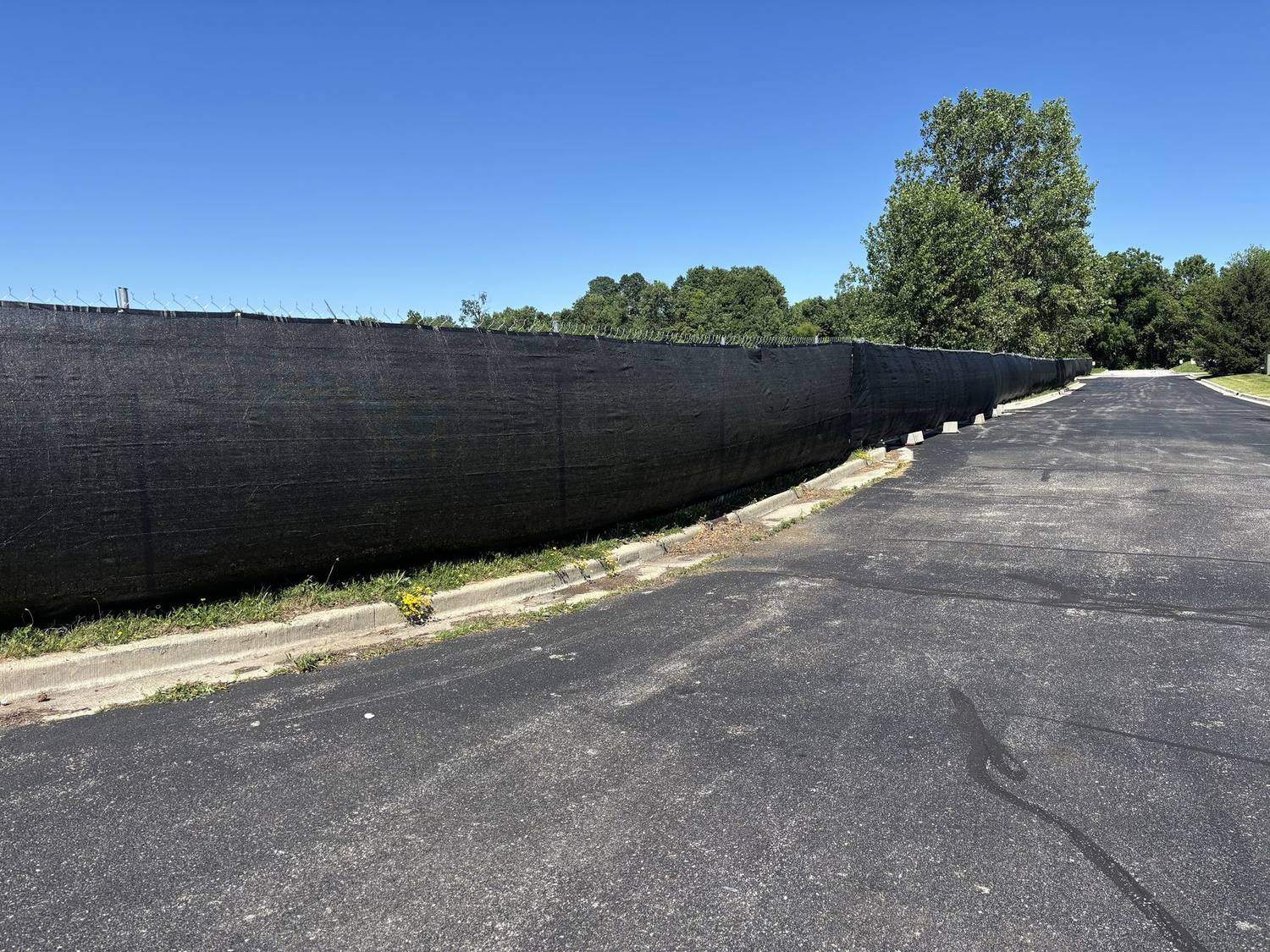 A long black windscreen run enclosing a paved lot