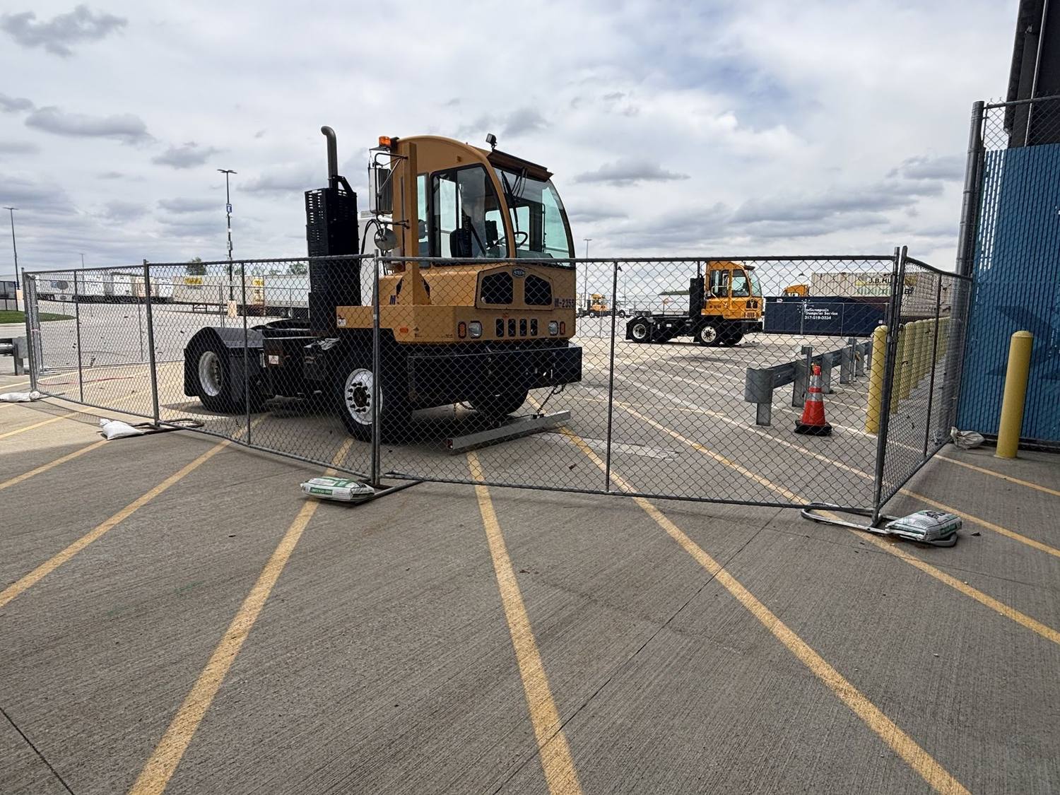 Temporary fence panels around a yard tractor at a commercial terminal